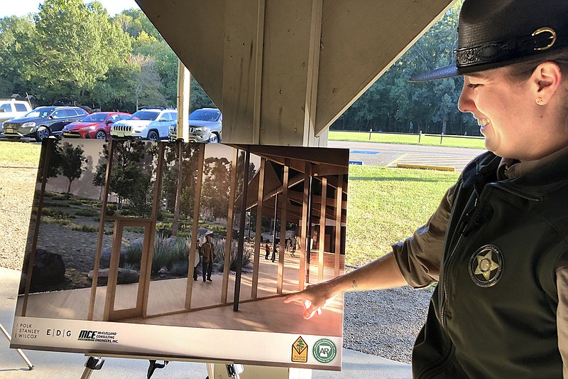 Molly Elders, superintendent of Lake Sylvia Recreation Area, points to a design rendering of the planned new visitor center for Pinnacle Mountain State Park during an open house Tuesday. Lake Sylvia became a unit of Pinnacle Mountain State Park in June.
(Arkansas Democrat-Gazette/Celia Storey)