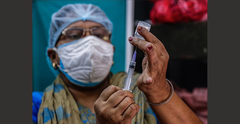 A health worker prepares a dose of Covaxin covid-19 vaccine Thursday at a health center in Garia, India, as the country marked the administering of its 1 billionth dose, passing the milestone in the wake of the delta variant’s crushing surge earlier this year.
(AP/Bikas Das)