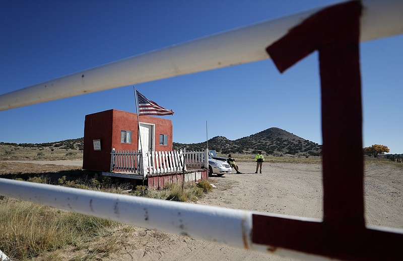 Private security guards stand at the entrance to the Bonanza Creek Ranch in Santa Fe, N.M., on Friday.
(AP/Andres Leighton)