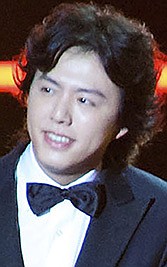 Chinese pianist Li Yundi appears on stage with Australian singer Kylie Minogue during the 2011 Elite Model Look contest in Shanghai on Dec. 6, 2011. Police in China's capital Beijing on Thursday, Oct. 21, 2021 say famed international pianist Li Yundi is a suspect in a prostitution case. (Chinatopix via AP)