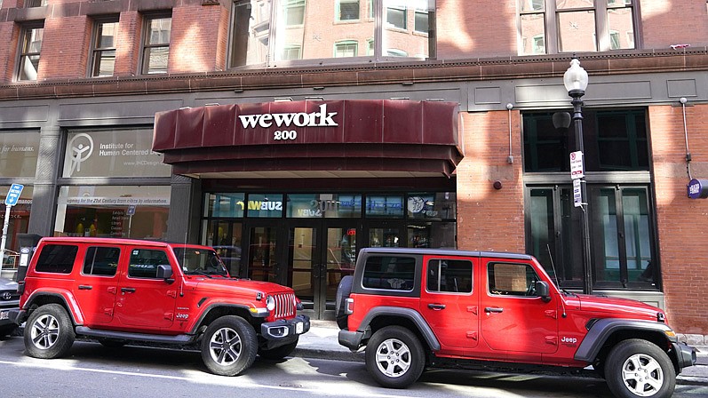 The WeWork logo is affixed to a building in Boston. The co-working company started trading on the New York Stock Exchange on Thursday, its second attempt at a stock offering following a failed attempt two years ago.
(AP/Charles Krupa)