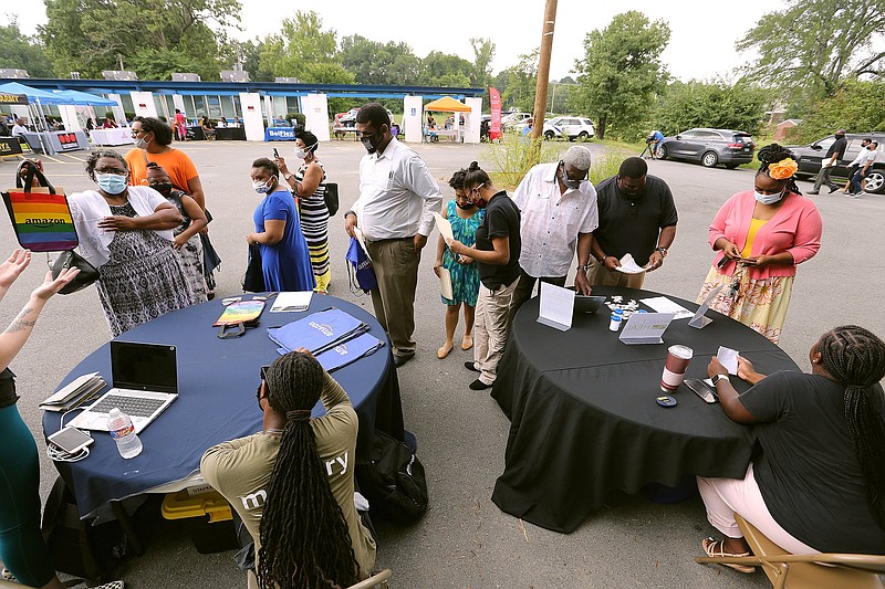 Job-seekers get information from employers’ booths during a job fair last summer at Watershed  Family Resource Center in Little Rock. 
(Arkansas Democrat-Gazette/Thomas Metthe)