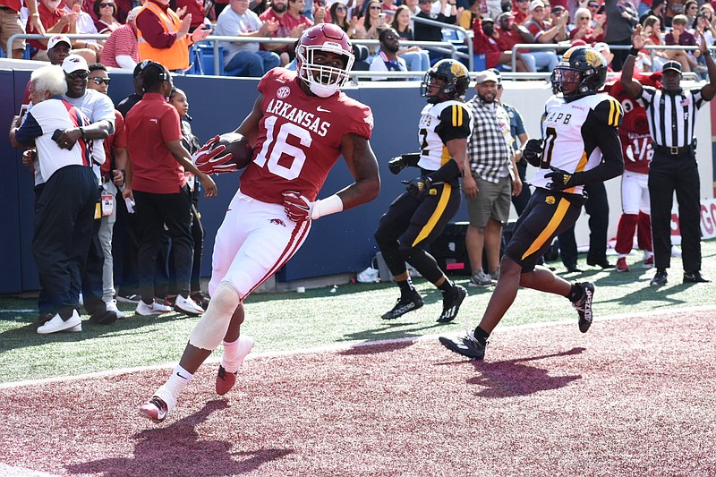 Arkansas receiver Treylon Burks of Warren races into the end zone on 49-yard touchdown carry during the first quarter of the Razorbacks' game against UA-Pine Bluff on Saturday, Oct. 23, 2021, in Little Rock. At right are UAPB defensive backs Marcus Askew (22) and Jalon Thigpen (0). (Pine Bluff Commercial/I.C. Murrell)