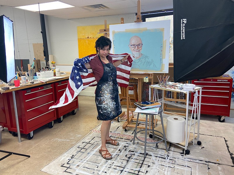 Virmarie DePoyster wraps herself in the American flag that she used in the signature piece of her exhibit,‘Beyond Labels | Más Allá De Las Etiquetas.’ It opens Oct. 28 at the Arts and Science Center for Southeast Arkansas at Pine Bluff. 
(Special to The Commercial/Deborah Horn)