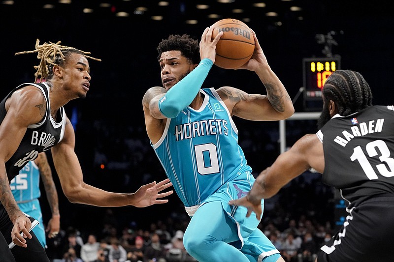 Charlotte Hornets forward Miles Bridges (center) drives past Brooklyn Nets guard James Harden (right) and forward Nic Claxton during the first half Sunday in New York. Bridges led the Hornets with 32 points in a 111-95 victory.
(AP/John Minchillo)