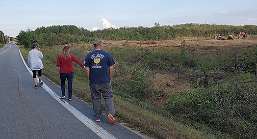 Pinnacle Mountain Community Coalition secretary Meredith Hawkins walks in front of Chris Centofante, the coalition president, and Matt Sprenger near the area planned to become the Paradise Valley Subdivision. The area shares a boundary with Centofante’s land. Centofante started the nonprofit to fight against the neighborhood and “leap frogging” or building a development in unincorporated area like Roland that she says does not have the infrastructure to support it.
(Arkansas Democrat-Gazette/Ashton Eley)