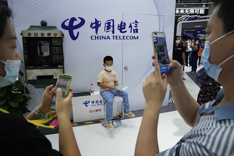Visitors take photos near an old telephone booth at the China Telecom stand during the China International Fair for Trade in Services in Beijing last month.
(AP/Ng Han Guan)