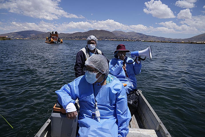 Health care workers motor across Lake Titicaca in Puno, Peru, on Wednesday with a load of coolers filled with doses of the Pfizer covid-19 vaccine as part of a door-to-door vaccination campaign.
(AP/Martin Mejia)