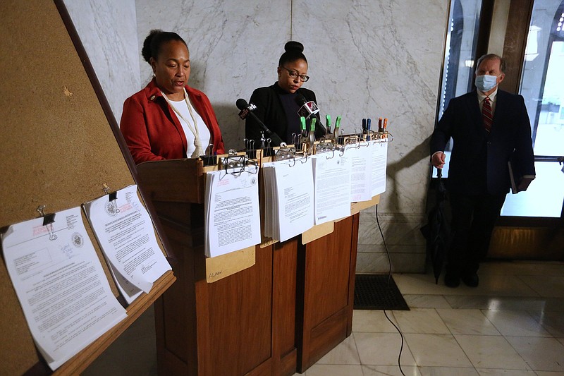 Pulaski Circuit County Clerk Terri Hollingsworth (left) reads of the description of the Park Plaza mall property with Kimberly Glover (center) while attorney Charles Glover (right) looks on as the mall is auctioned on Thursday at the Pulaski County Courthouse.
(Arkansas Democrat-Gazette/Thomas Metthe)