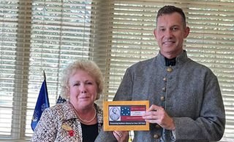 Randall Freeman, commander of the Sons of Confederate Veterans, General Robert C. Newton #197 Camp, presents a check to Pat McLemore, president of the Baseline-Meridian Chapter of the United States Daughters of 1812, at the Triad meeting at the Pine Bluff Country Club. 
(Special to The Commercial)