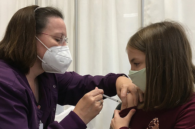 Ansley Johnson, 10, of Little Rock gets her first covid-19 shot Wednesday from Arkansas Department of Health Communicable Disease nurse specialist Angela Hopton at the department’s central health unit in Little Rock.
(Arkansas Democrat-Gazette/Andy Davis)