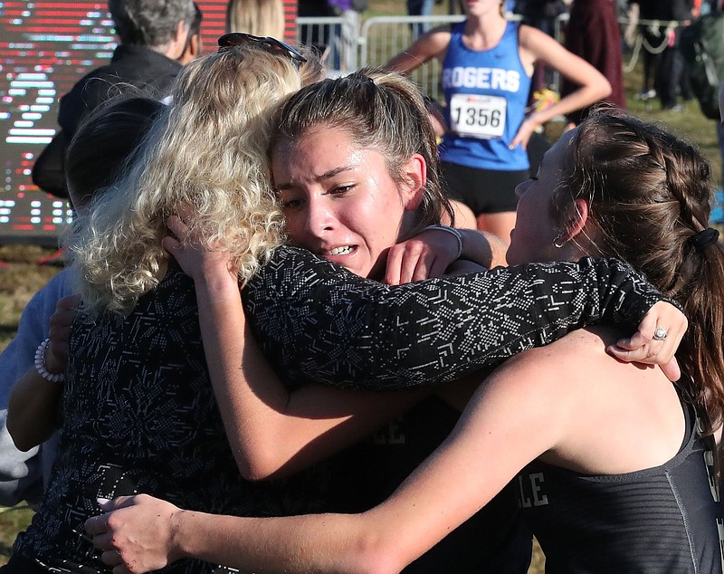 Madison Galindo of Bentonville gets a hug Thursday after winning the Class 6A Girls State Cross Country Championship at Oaklawn Racing Casino Resort in Hot Springs. Galindo defeated Carson Wasemiller of Fayetteville by nearly 19 seconds.
(The Sentinel-Record/Richard Rasmussen)