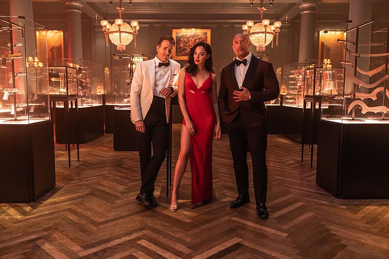 International con artist Nolan Booth (Ryan Reynolds) and art thief Sarah Black (Gal Gadot) are chased around the globe by FBI profiler John Hartley (Dwayne Johnson) in “Red Notice,” the most expensive Netflix production to date.