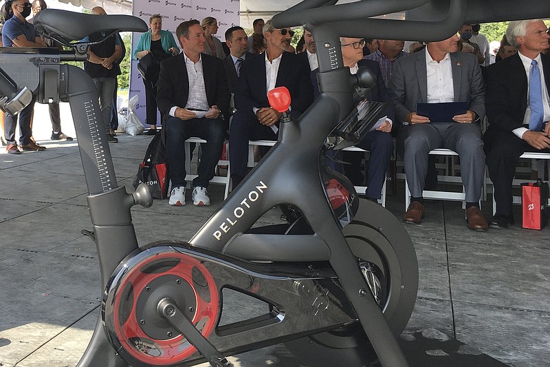 Peloton CEO John Foley (left) is seen behind one of his company’s fitness machine along with others gathered for the groundbreaking for the company’s first U.S. factory in Luckey, Ohio. Investors bailed on Peloton, Friday, after the company said it expected to lose more money than previously forecast in 2022.
(AP/John Seewer)