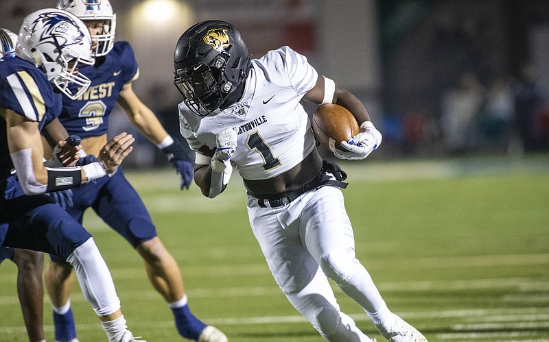 Bentonville’s Josh Ficklin (right) outruns two Bentonville West defenders Friday during the Tigers’ 56-14 victory over the Wolverines in Centerton. More photos at arkansasonline.com/116benwest/.
(Special to the NWA Democrat-Gazette/David Beach)