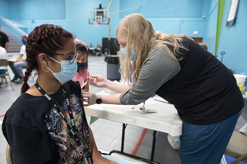 FILE -- Ariana Laos gets vaccinated by Gracie Powell a registered nurse during a flu and covid vaccination clinic at the Rogers Activities Center Friday Oct 1, 2021, in Rogers. (NWA Democrat-Gazette/Spencer Tirey)