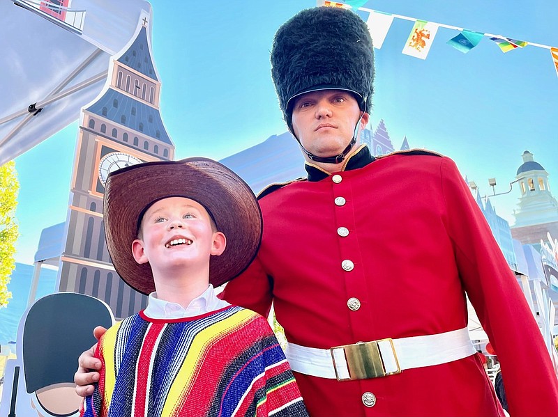 Dressed like a member of the Queen’s Guard, Chris Herring (right) stood watch near the United Kingdom food both Sunday, guarding the scones and posing for pictures with visitors. First Pentecostal Church in North Little Rock organized the free event, which included dishes from nearly two dozen countries.
(Arkansas Democrat-Gazette/Frank E. Lockwood)