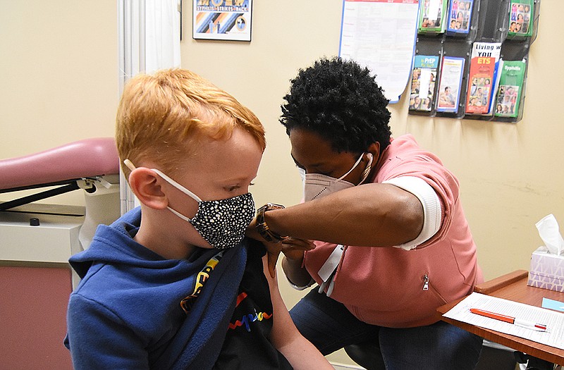 Easton Gracey, 7, receives his first dose of the coronavirus vaccine from Amina Reeder, a registered nurse coordinator, Saturday at the Pulaski County Central Health Unit in Little Rock.
(Arkansas Democrat-Gazette/Staci Vandagriff)