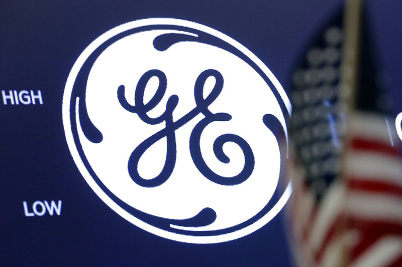 FILE - The General Electric logo appears above a trading post on the floor of the New York Stock Exchange, June 26, 2018. General Electric is splitting itself into three public companies that concentrate on aviation, healthcare and energy. The company said Tuesday, Nov. 9, 2021, that it plans a spinoff of its healthcare business in early 2023 and of its energy segment in early 2024. (AP Photo/Richard Drew, File)