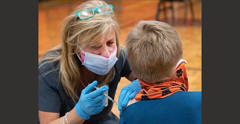 Nurse Tami Herndon of the Mount Rogers Health District in Bristol, Va., gives John Price a covid-19 shot Wednesday during a clinic at Van Pelt Elementary School in Bristol. The after-school clinic had more than 80 appointments for the day.
(AP/Bristol Herald Courier/David Crigger)
