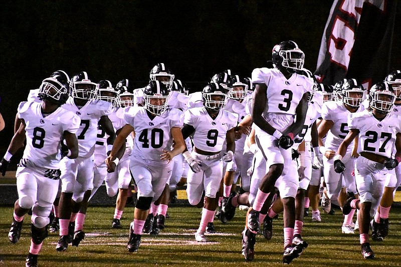 The White Hall Bulldogs break through their gameday sign and take the field Oct. 15 before a game at Watson Chapel. Bulldogs coach Bobby Bolding said that the first-round playoff matchup against the “well coached” Farmington Cardinals will, “definitely be a challenge.” 
(Pine Bluff Commercial/I.C. Murrell)