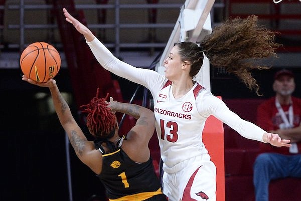 Arkansas guard Sasha Goforth (13) reaches to block a shot Friday, Nov. 12, 2021, by UAPB guard Tyeisha Juhan (1) during the first half of play in Bud Walton Arena in Fayetteville.