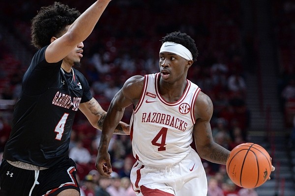 Arkansas guard Davonte Davis drives to the lane on Saturday, Nov. 13, 2021, as he is pressured by Gardner-Webb guard D’Maurian Williams during the second half of the Razorbacks’ 86-69 win in Bud Walton Arena.