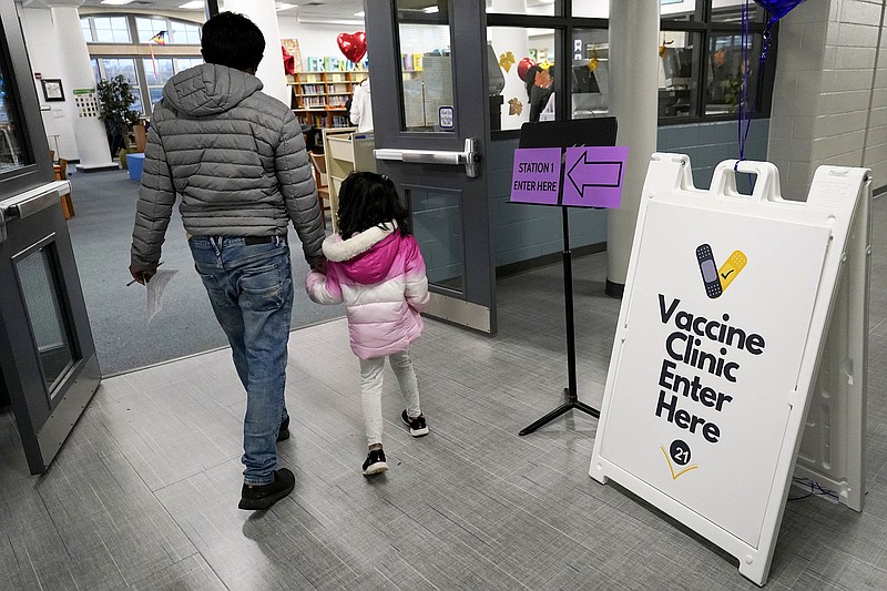 A parent and child arrive Wednesday at a Pfizer covid-19 vaccination clinic for children 5- to 11-years old at London Middle School in Wheeling, Ill.
(AP/Nam Y. Huh)