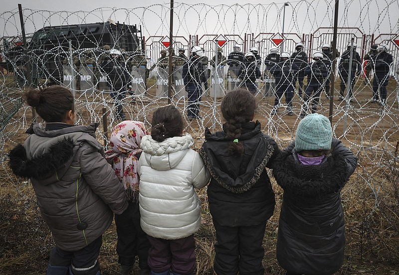 Migrant children near Grodno, Belarus, gather Wednesday in front of a barbed-wire fence guarded by Polish servicemen at the border. More photos at arkansasonline.com/1118grodno/.
(AP/BelTA/Maxim Guchek)