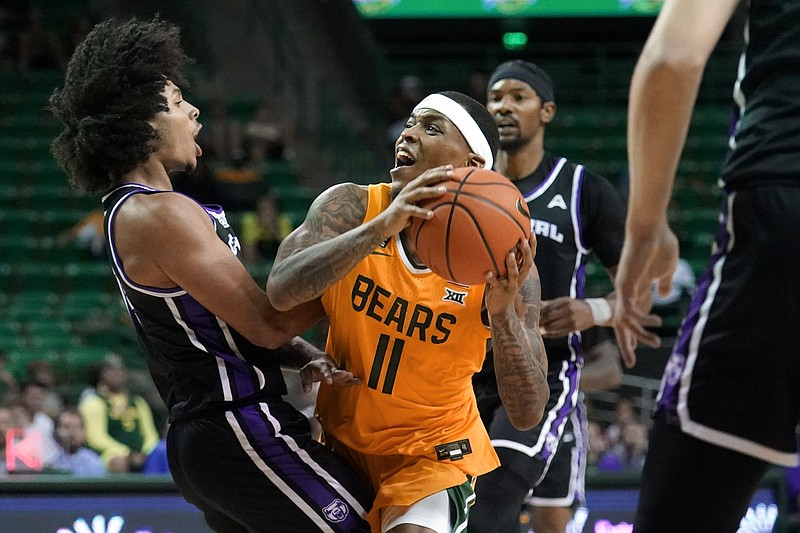 University of Central Arkansas guard Collin Cooper (left) takes a charge Wednesday on a drive to the basket by Baylor guard James Akinjo (11) during the second half of No. 9 Baylor’s 92-47 victory in Waco, Texas.
(AP/Tony Gutierrez)