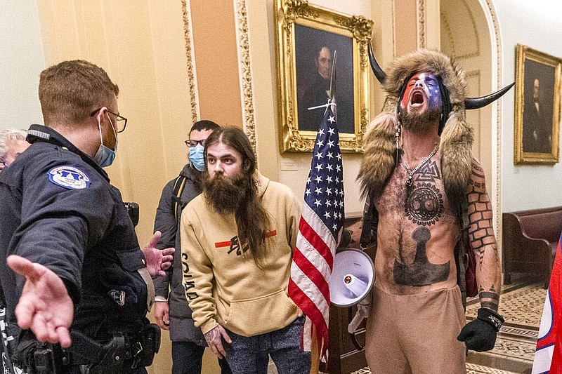 FILE - Supporters of President Donald Trump, including Jacob Chansley, right with fur hat, are confronted by U.S. Capitol Police officers outside the Senate chamber inside the Capitol during the capitol riot in Washington, Jan. 6, 2021.(AP Photo/Manuel Balce Ceneta, File)