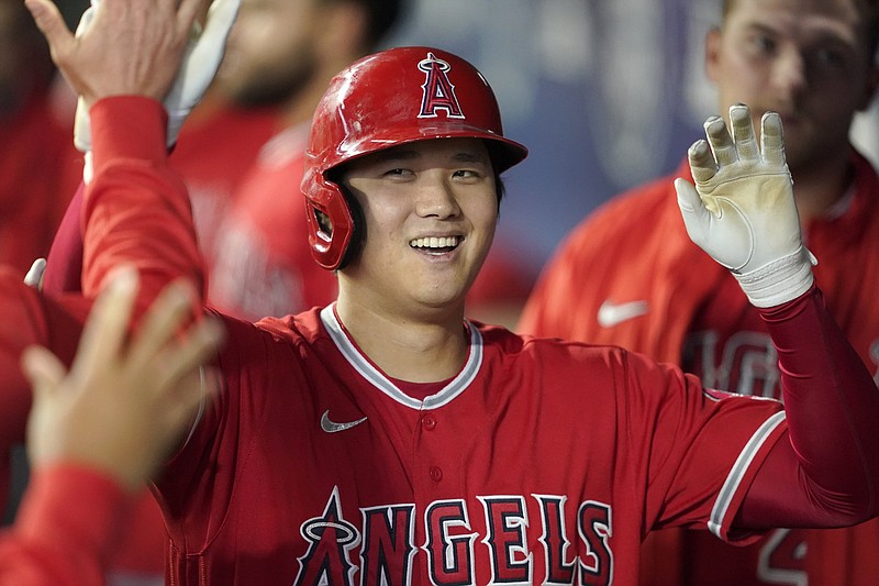 FILE - Los Angeles Angels' Shohei Ohtani is greeted in the dugout after he hit a solo home run during the first inning of a baseball game against the Seattle Mariners, Sunday, Oct. 3, 2021, in Seattle. On Thursday, Nov. 18, 2021, Ohtani was unanimiously voted American League MVP for a two-way season not seen since Babe Ruth. (AP Photo/Ted S. Warren, File)