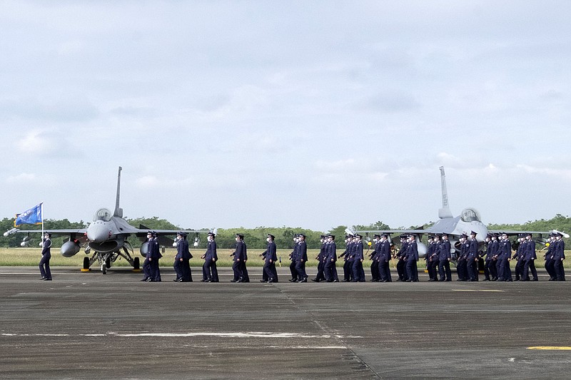 Members of the Taiwanese air force march past two of the newly commissioned upgraded F-16V fi ghter jets Thursday at an air force base in Chiayi in southwestern Taiwan.
(AP/Johnson Lai)