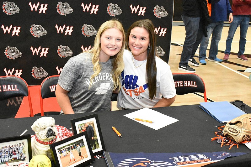 White Hall High School softball teammates Sophie Weaver (left) and Lilly Hood sit next to each other Thursday during their signing ceremonies at the school’s gymnasium. Weaver officially committed to Henderson State University, and Hood will attend the University of Texas at San Antonio. 
(Pine Bluff Commercial/I.C. Murrell)