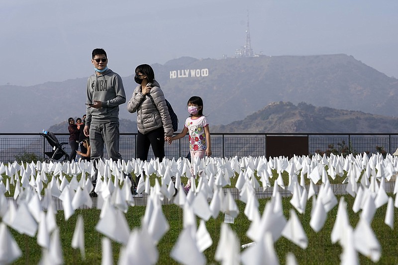 Visitors walk through a covid-19 memorial Friday at the Griffith Observatory in Los Angeles. Thousands of flags were placed on the lawn in front of the observatory representing people who have died of the disease in Los Angeles County as of Nov. 2.
(AP/Marcio Jose Sanchez)