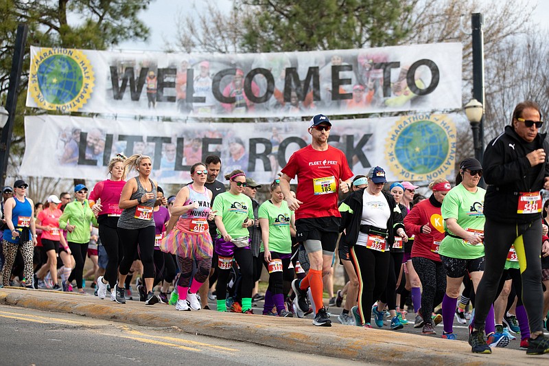 Little Rock Marathon participants run past the Welcome to Little Rock sign in the downtown area on March 1, 2020, the last time the event was held. This year’s race, postponed from March because of covid-19 concerns, is set to start at 8 a.m. Sunday with a limited field of 1,200 participants.
(Arkansas Democrat-Gazette/Justin Cunningham)