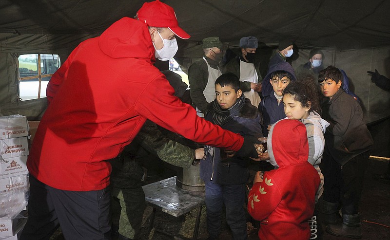 Belarusian Red Cross employees hand over humanitarian aid to migrants in the logistics center in the checkpoint “Kuznitsa” at the Belarus-Poland border near Grodno, Belarus, on Friday.
(AP/BelTA/Leonid Shcheglov)