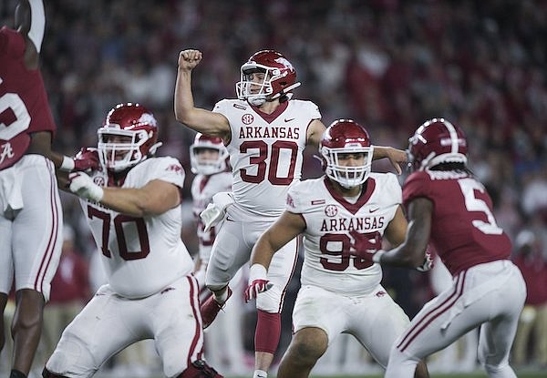 Arkansas punter Reid Bauer (30) throws a touchdown pass during a game against Alabama on Saturday, Nov. 20, 2021, in Tuscaloosa, Ala.