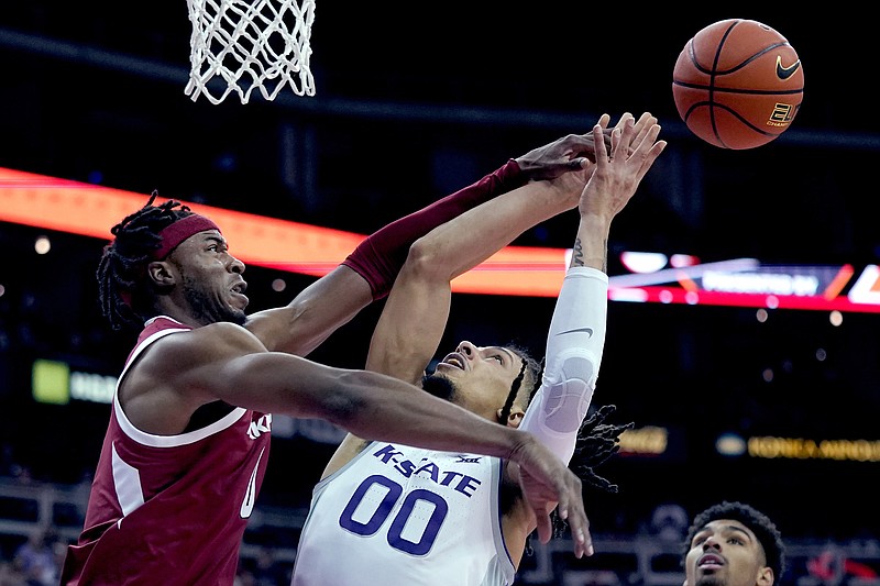 Arkansas' Stanley Umude, left, blocks a shot by Kansas State's Mike McGuirl (00) during the first half of an NCAA college basketball game Monday, Nov. 22, 2021, in Kansas City, Mo. (AP Photo/Charlie Riedel)
