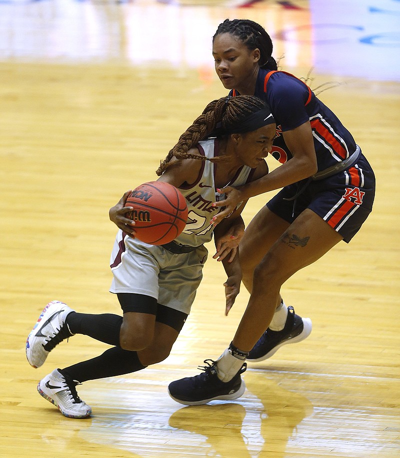 UALR’s Mayra Caicedo (left) drives toward the basket while being  guarded by Auburn’s Mar’shaun Bostic during the Trojans’ victory  over the Tigers on Wednesday at the Jack Stephens Center in Little Rock.
(Arkansas Democrat-Gazette/Thomas Metthe)