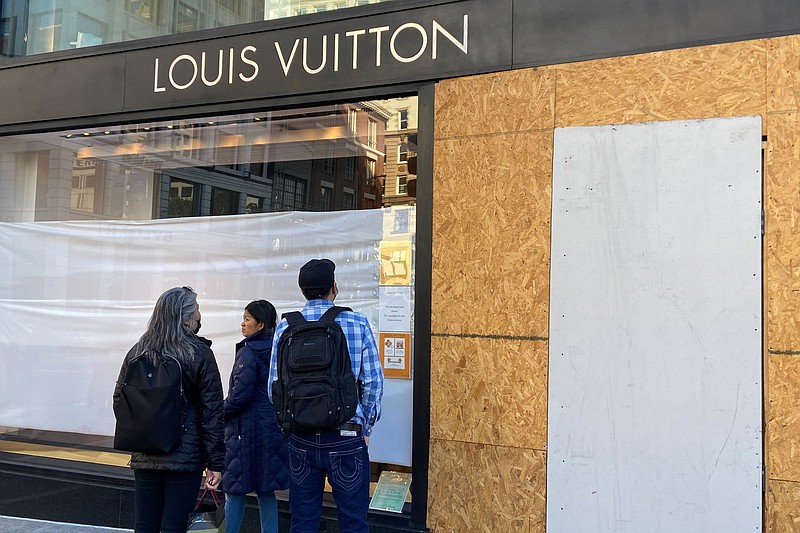 Visitors at San Francisco’s Union Square look at the damage to a Louis Vuitton store Sunday after thieves ransacked the business.
(AP/San Francisco Chronicle/Danielle Echeverria)