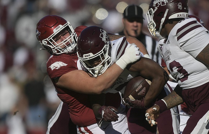 Defensive lineman John Ridgeway (99), seen here tackling Mississippi State running back Jo’quavious Marks during a Nov. 6 game in Fayetteville, has been one of Arkansas’ top defensive players this season after transferring from Illinois State in the offseason.
(NWA Democrat-Gazette/Charlie Kaijo)