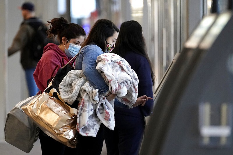 Post-Thanksgiving travelers wear masks as they check in at the American Airline self-ticket counter at O'Hare International Airport in Chicago in this Nov. 29, 2020, file photo. (AP/Nam Y. Huh)