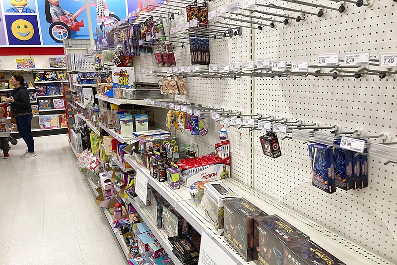 A shopper passes by empty racks used for displaying toys in a Target store in Lakewood, Colo., in this Oct. 26, 2021, file photo. (AP/David Zalubowski)