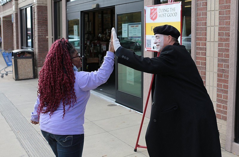 Marvin Fisher of Sherwood, a Salvation Army volunteer bell ringer, gets a high-five from Kristina Scott of Little Rock as she passes by the entrance of Hobby Lobby in North Little Rock. Maj. Bill Mockabee, the head of the Central Arkansas Salvation Army, said Fisher is a longtime volunteer. “He always has costumes of some sort on,” Mockabee said. “He makes it fun.”
(Arkansas Democrat-Gazette/Dale Ellis)