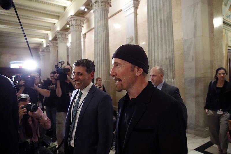 U2's the Edge, center, walks on Capitol Hill in Washington, Tuesday, June 19, 2018. (AP Photo/Alex Brandon)