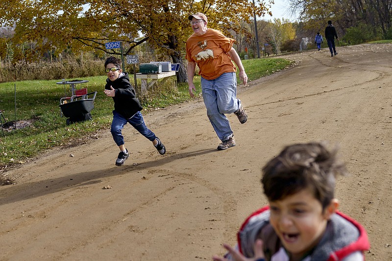 Caroline Clarin races 9-year-old Sala Patan (left), and his brother, Ali, 7, during a visit to her home in Dalton, Minn., with their father, Ihsanullah Patan, a horticulturist who Clarin helped leave Afghanistan with his family.
(AP/David Goldman)