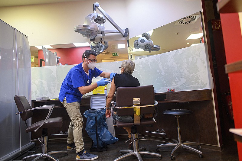 A woman gets a covid-19 shot Thursday at a vaccination clinic set up in a former hair salon in a shopping center in Magdeburg, Germany.
(AP/dpa/Klaus-Dietmar Gabbert)