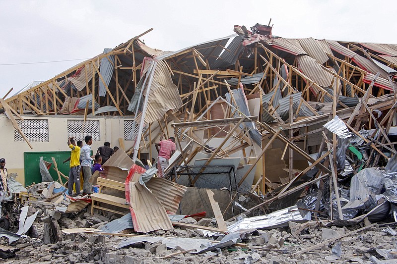 People search for bodies Thursday at the scene of a blast in Mogadishu, Somalia. Video at arkansasonline.com/1126somalia/.
(AP/Farah Abdi Warsameh)