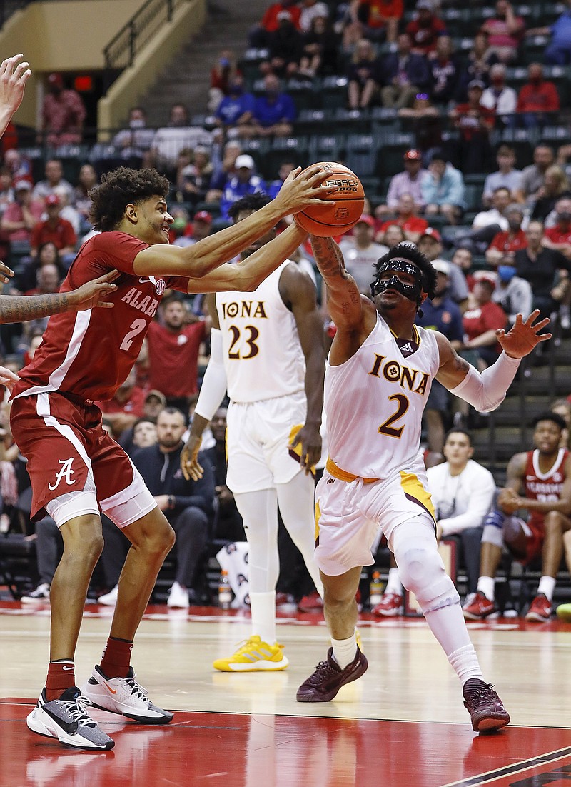 Alabama forward Darius Miles (left) and Iona guard Elijah Joiner vie for the ball during the second half in an opening-round game at the ESPN Events Invitational on Thursday in Orlando, Fla. The Gaels upset the 10th-ranked Crimson Tide 72-68.
(AP/Jacob M. Langston)